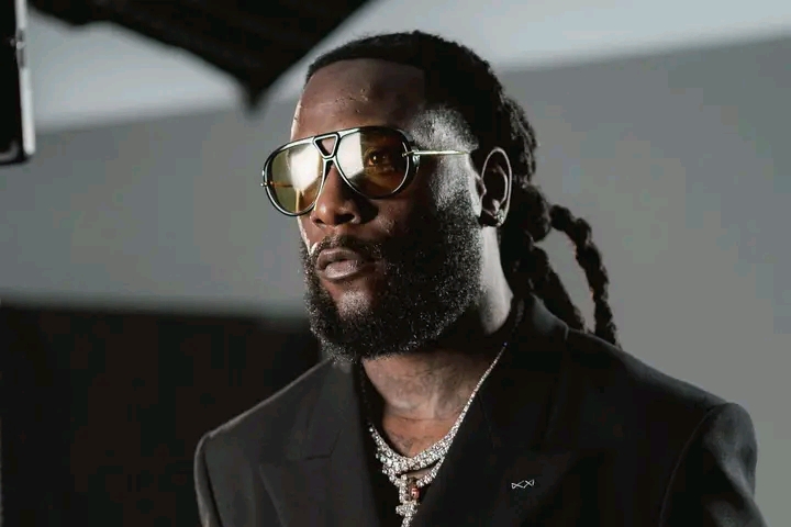 Burna Boy in sunglasses and a black jacket
